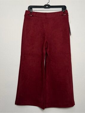 Burgundy faux-suede wide-leg pants featuring metallic side buckles.